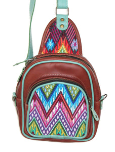 MoonLake Designs Blake Sling Over Backpack Bag in red brown (burnt sienna) handcrafted leather with fun geometric huipil design in blue, pink, purple, and green with teal leather adjustable strap and accents