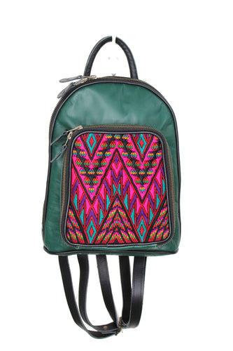 Petite small cute backpack purse in dark green leather and black leather straps and accents.. It has double zipper openings. Front pocket is eye catching with a geometrichot pink, purple, black and teal green textile. this pocket has storage for pens and credit cards. Main compartment has two open pockets and a zipper pocket.