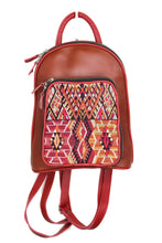 Load image into Gallery viewer, Petite small cute backpack purse in a red brown leather and rusty red leather accent. It has double zipper openings. Front pocket is eye catching with a geometric textile in reds, orange, brown and cream with a touch of mellow yellow. This pocket has storage for pens and credit cards. Main compartment has two open pockets and a zipper pocket.