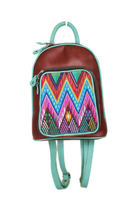Petite small cute backpack purse in red brown leather and teal leather straps and accent. It has double zipper openings. Front pocket has storage for pens and credit cards. Main compartment has two open pockets and a zipper pocket.
