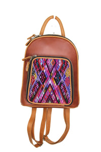 Petite small cute backpack purse in red brown leather and pear leather straps and accents.. It has double zipper openings. Front pocket is eye catching with a geometric purple, black, pink and pear yellow textile. this pocket has storage for pens and credit cards. Main compartment has two open pockets and a zipper pocket.
