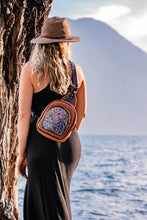 Load image into Gallery viewer, MoonLake Designs Blake sling over backpack with stunning huipil design worn by woman wearing black dress watching the water