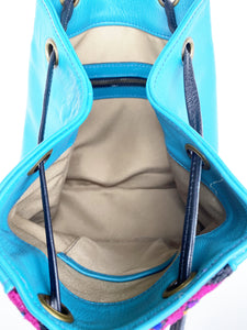 MoonLake Designs Maya bucket backpack inside view of electric blue leather, light cream cloth interior, and zippered pocket
