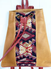 Load image into Gallery viewer, MoonLake Designs Maya bucket backpack in handcrafted pear tan leather close up view of geometric huipil design in rusty red, light tans, and complementary colors and adjustable draw string