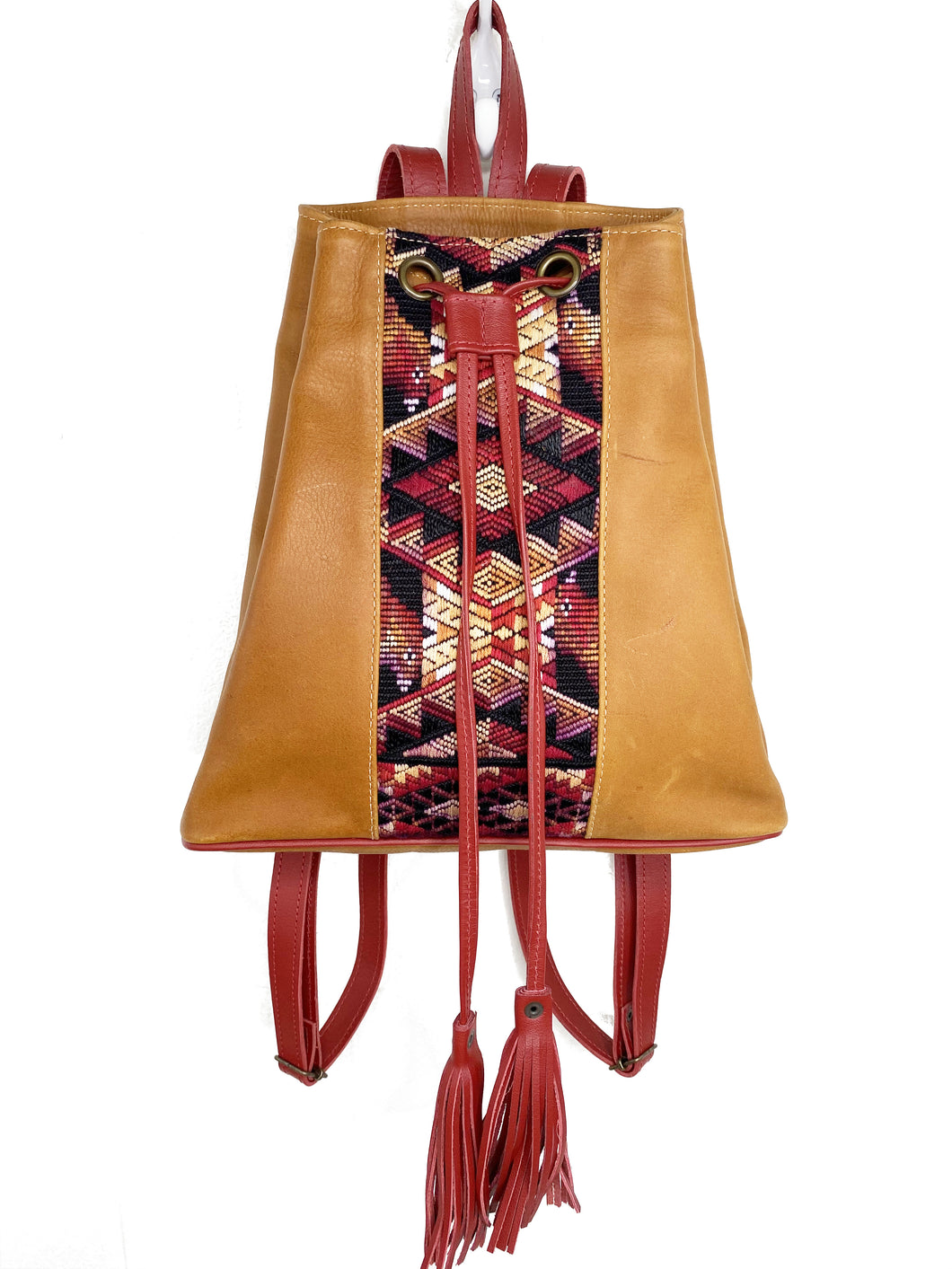 MoonLake Designs Maya bucket backpack in handcrafted pear tan leather with Mayan geometric huipil design and rusty red leather draw straps, backpack straps, and fringe ties