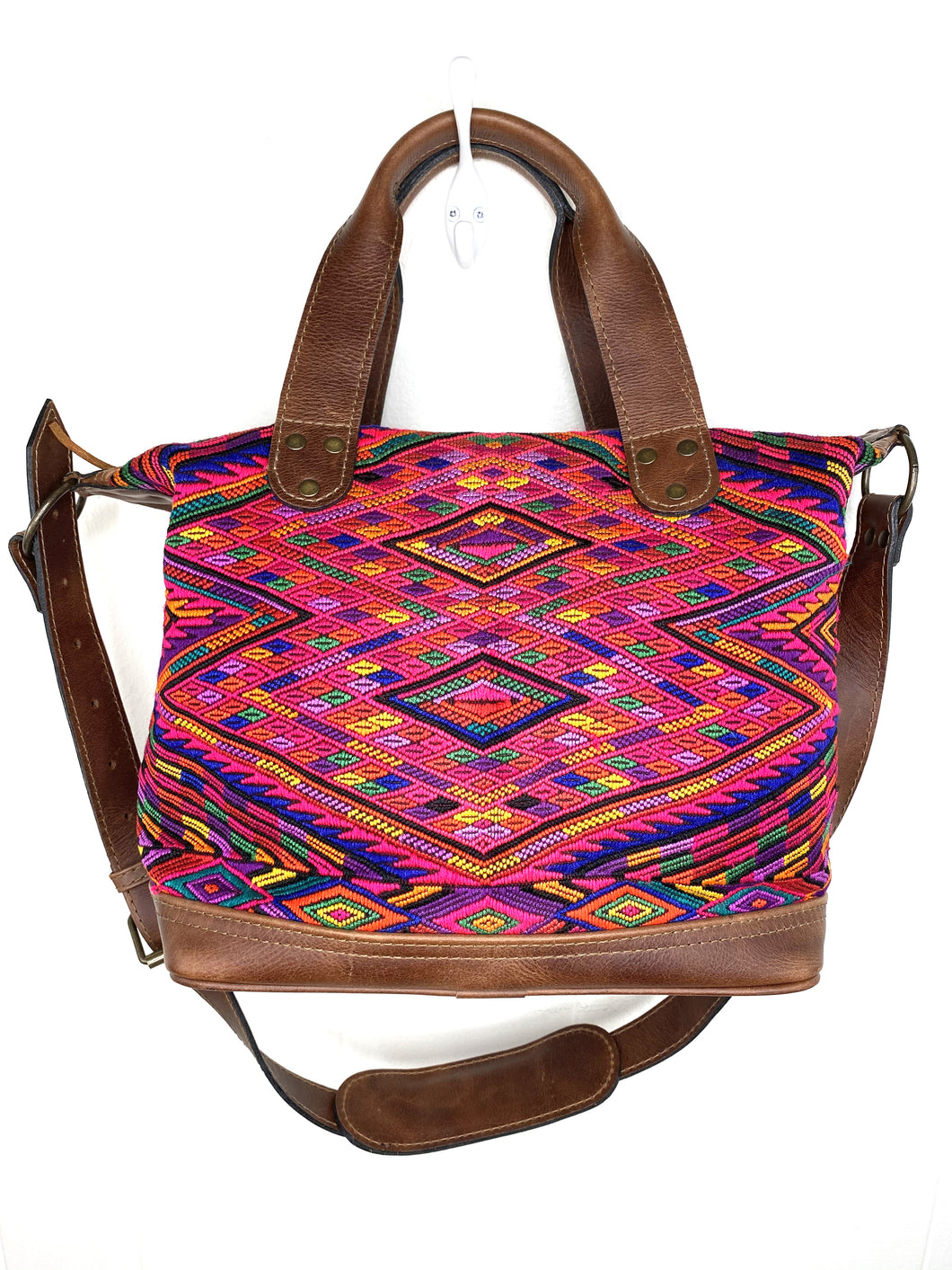 MoonLake Designs handmade Renata Medium Maleta Crossbody Bag in Dark Tan leather with handwoven huipil design featuring pinks, purples, oranges and more in a geometric panel